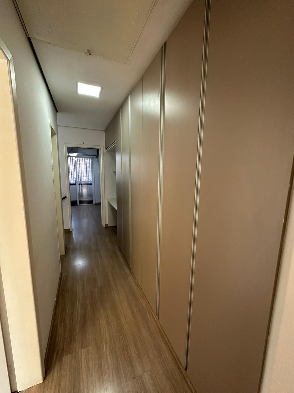 Corredor de circulação com roupeiro planejado embutido de grande porte